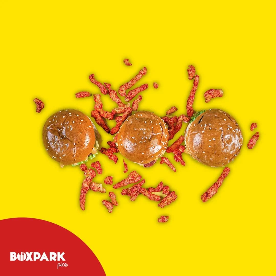 Three sliders scattered with Cheetos on yellow