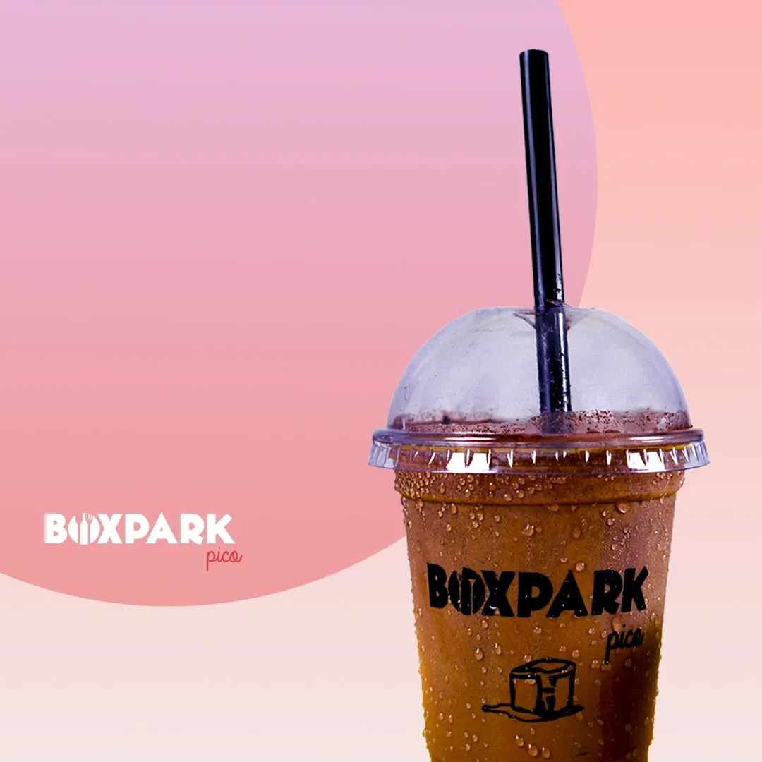 An iced coffee cup on a pink gradient