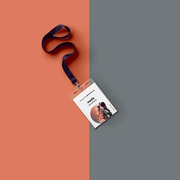 A media accreditation badge on a navy lanyard, laid on a split terracotta and slate background