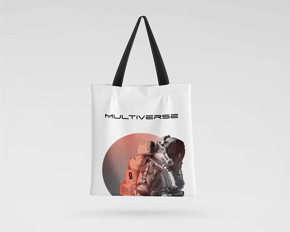 A white tote bag printed with the MULTIVERSE wordmark and the astronaut in the terracotta circle