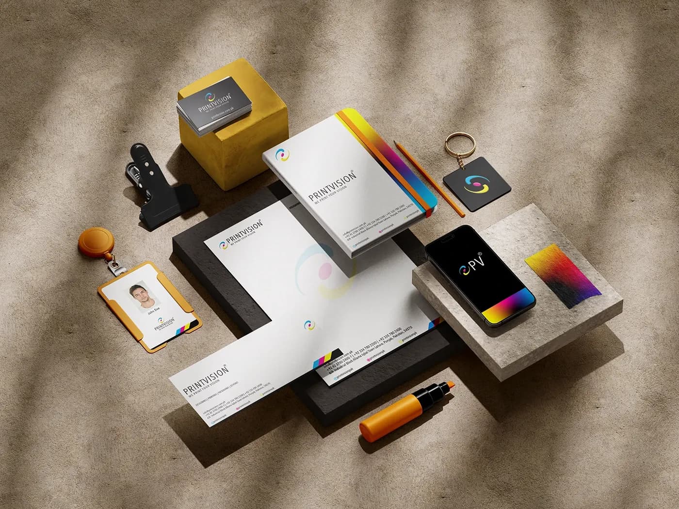 Stationery system arranged on a textured surface with CMYK detailing