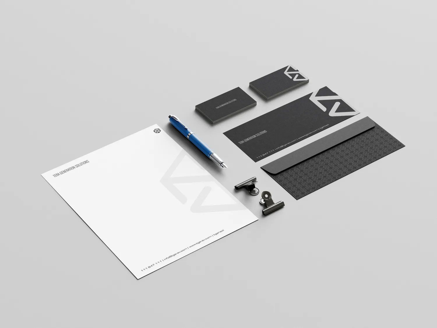 Letterhead, business cards and a patterned envelope in charcoal and white with the TGS mark